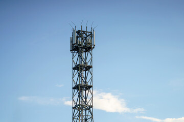 Steel goliath reaching for a serene sky, communication tower under the gentle daylight of a summer...