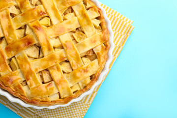 Tasty homemade apple pie on light blue background, top view. Space for text