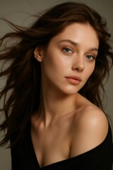 Fototapeta premium Young woman posing for a natural beauty portrait, featuring clear skin and windblown long brunette hair, highlighting natural aesthetics