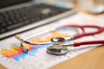 Medical Stethoscope and Glasses on Financial Report with Laptop.