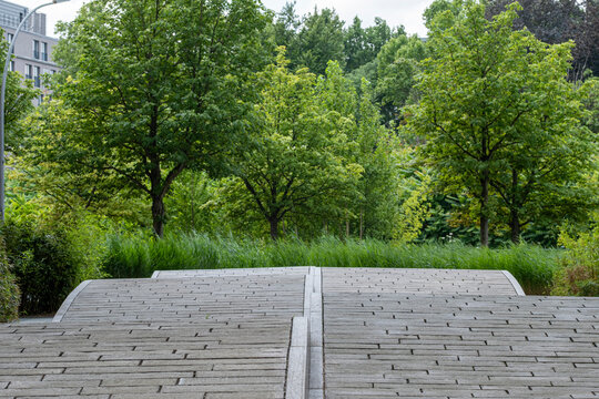 Modern urban park with greenery architecture and pathway surrounded by trees and landscape design blending nature into the city atmosphere under soft daylight