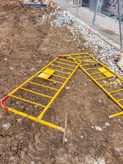 Broken Yellow Barrier Lying on Construction Ground