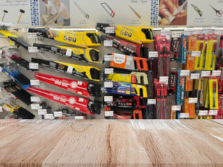 Fototapeta premium Wooden table top (counter bar) with blured Hand tools on shelf display at store for background. Banner for advertise on online media. For montage product display visual layout. Shopping concepts.