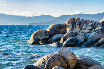 Lake Tahoe Nevada USA rocky shoreline with large smooth granite boulders and clear blue water scenic mountain landscape at sunset calm nature view travel destination and outdoor adventure scene