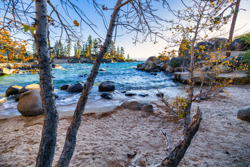 Sand Harbor State Park at Lake Tahoe Nevada USA scenic rocky shoreline with turquoise water and golden sunset light reflecting on waves beautiful outdoor travel destination surrounded by pine trees