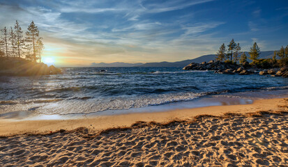 Sand Harbor State Park at Lake Tahoe Nevada USA scenic rocky shoreline with turquoise water and golden sunset light reflecting on waves beautiful outdoor travel destination surrounded by pine trees