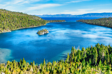 Emerald Bay Lake Tahoe California USA panoramic view of blue lake water surrounded by green pine forest and Sierra Nevada mountains under clear sky popular travel and nature destination