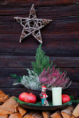 Adventsdekoration vor altem Holzhaus 