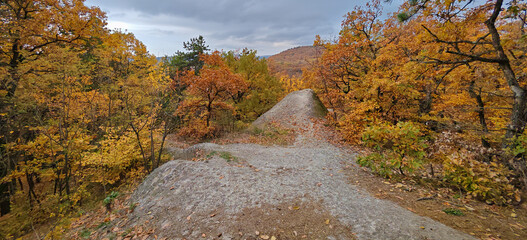 Panoramic view of the Devil’s Slide rock formation surrounded by autumn trees in the Bükk Mountains, Hungary.