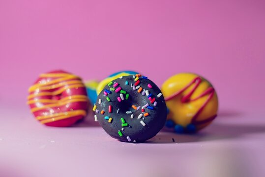 Close-up de mini donas caseras decoradas con colores brillantes de glas&eacute; y grageas con edici&oacute;n vintage