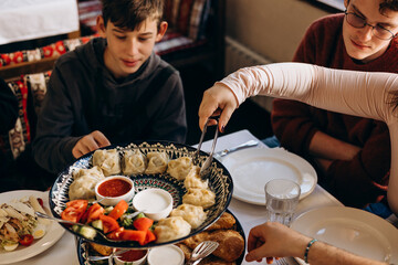 Friends dining in Georgian style restaurant with traditional dishes.