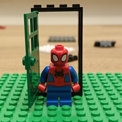 Naklejka premium Spider-Man Lego minifigure stands at an open doorway made of Lego bricks
