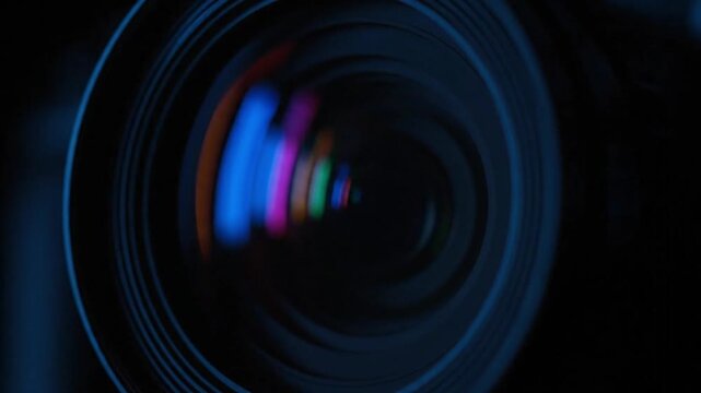 Close-up of a camera lens with colorful light reflections creating an abstract effect.