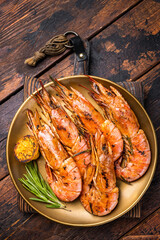 Grilled red Argentine shrimps, Prawns Langostino Austral on a plate with herbs. wooden background. top view