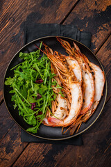 Seafood dinner with  Grilled red Shrimps Prawns Langostino Austral on a plate with salad. wooden background. top view