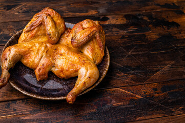Baked chicken Tabaka Tobacco with spices, poultry meat on plate. wooden background. top view
