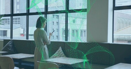 Standing woman in dress holding phone, looking through window at cafe lounge, copy space
