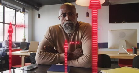 Sitting African American man crossing arms at desk in open-plan office, with analytics overlay