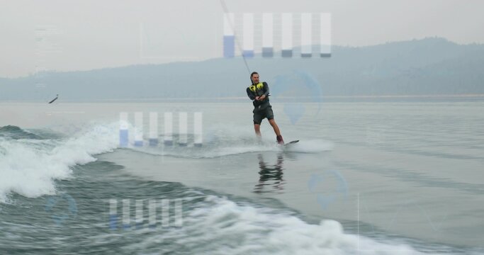 Gliding man wearing neon life vest on wakeboard across lake, gripping tow rope amid boat wake