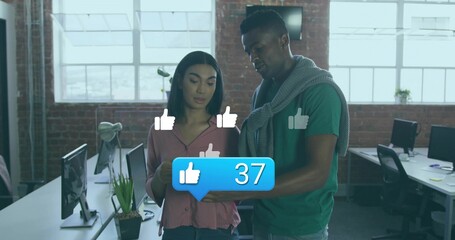 Collaborating coworkers reviewing tablet in open-plan office with likes overlay showing 37