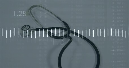 Resting black stethoscope lying on bluish surface, showing white waveform and data grid