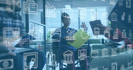 Diverse office team discussing financial data around wheelchair user in lounge, with green folder