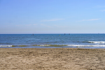 vacation in the Mediterranean. beach with people paddle surfing in the background