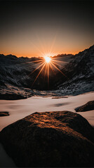 Breathtaking mountain sunrise over snowy landscape with stunning starburst effect