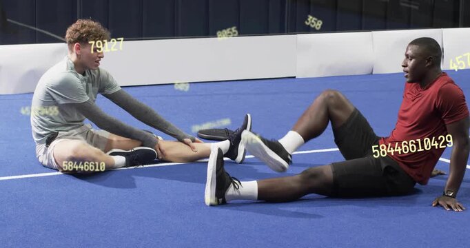 Training partners starting warmup doing hamstring stretches on blue court with yellow overlays