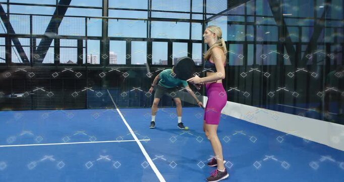 Opponent serving ball on padel court, male player lunging backhand shot as female player bracing