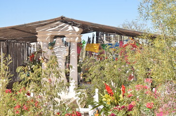 Touching memorial honors family heritage with vibrant flowers and decorative banners in a desert setting on a bright sunny day, evoking remembrance
