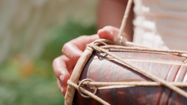 Close up of lady in white gown holding kalimba under warm sunlight, fingers touching instrument gently, natural light reflecting on skin and strings, expressing tenderness,