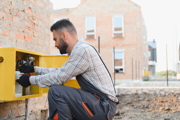 Gas utility technician installing meter at a new building