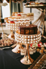 Vertical picture with candy bar. Sweets placed on pompous stands of gold and merle.