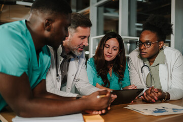 Diverse medical team collaborating using digital tablet