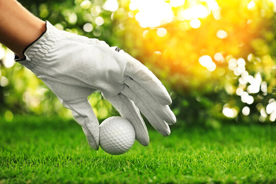 Player putting golf ball on green course, closeup - Powered by Adobe