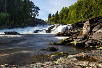 White water river rapids long exposure low angle rocks near Ristafallet waterfall in Sweden