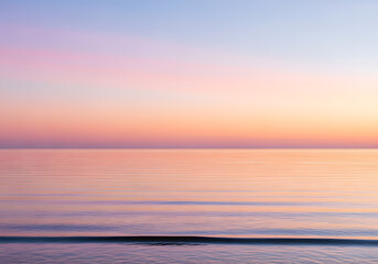 Fototapeta premium Pastel Sunset Sky Over Calm Ocean Water