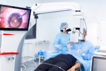 A doctor performs eye surgery in an operating room. Concepts of eye diseases, ophthalmology, vision health, vision diagnostics, and the medicine of the future.