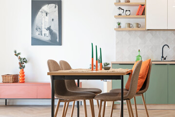 Interior of Modern kitchen and wooden dining table with chairs. New home with elegant design and picture on the wall. Real estate.	
