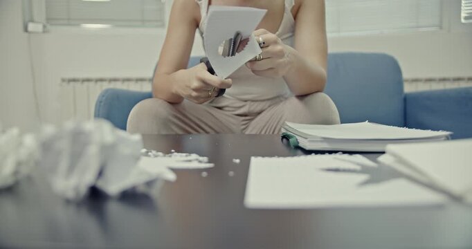 Observe a woman as she meticulously uses decorative scissors to cut paper into unique shapes, creating satisfying and crisp sounds. This video highlights a creative hobby at home.