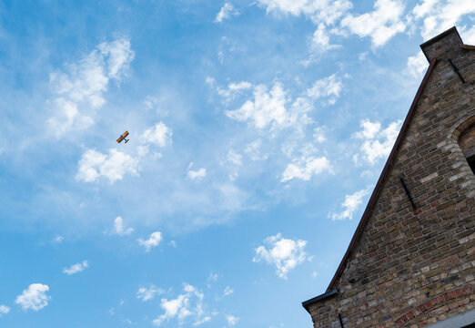 Avioneta pasando entre las nubes del cielo de Brujas