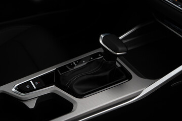 Car interior indoor. Black leather automatic gearbox with chrome button