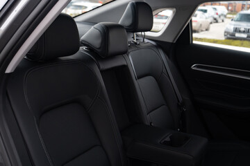 Cars passenger back rear seats armrest in black color with cup holders. Passage's seats made of genuine leather