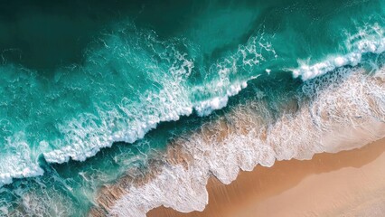 Aerial view of turquoise waves rolling onto a sandy beach with white foam along the shore. Concept Aerial Beach View, Turquoise Waves, White Foam on Sand, Sandy Shoreline