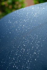 Close-up of small water droplets on a blue umbrella fabric after rainfall.