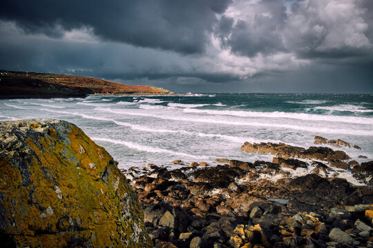 Sunlight and Storm Clouds over Rugged Cornwall Coastline