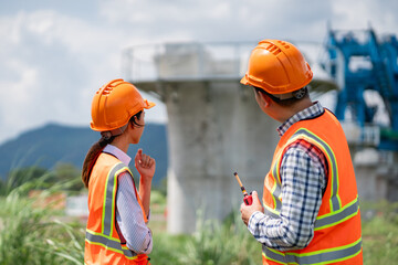Civil engineers use surveying tools and a theodolite to measure and reference road construction plans during the ongoing project.