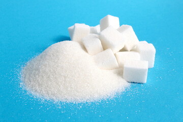 There are cubes of refined sugar lying on a pile of granulated sugar.	
