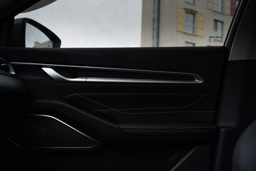 Interior door of a modern car. Front handle door panel with buttons of a car